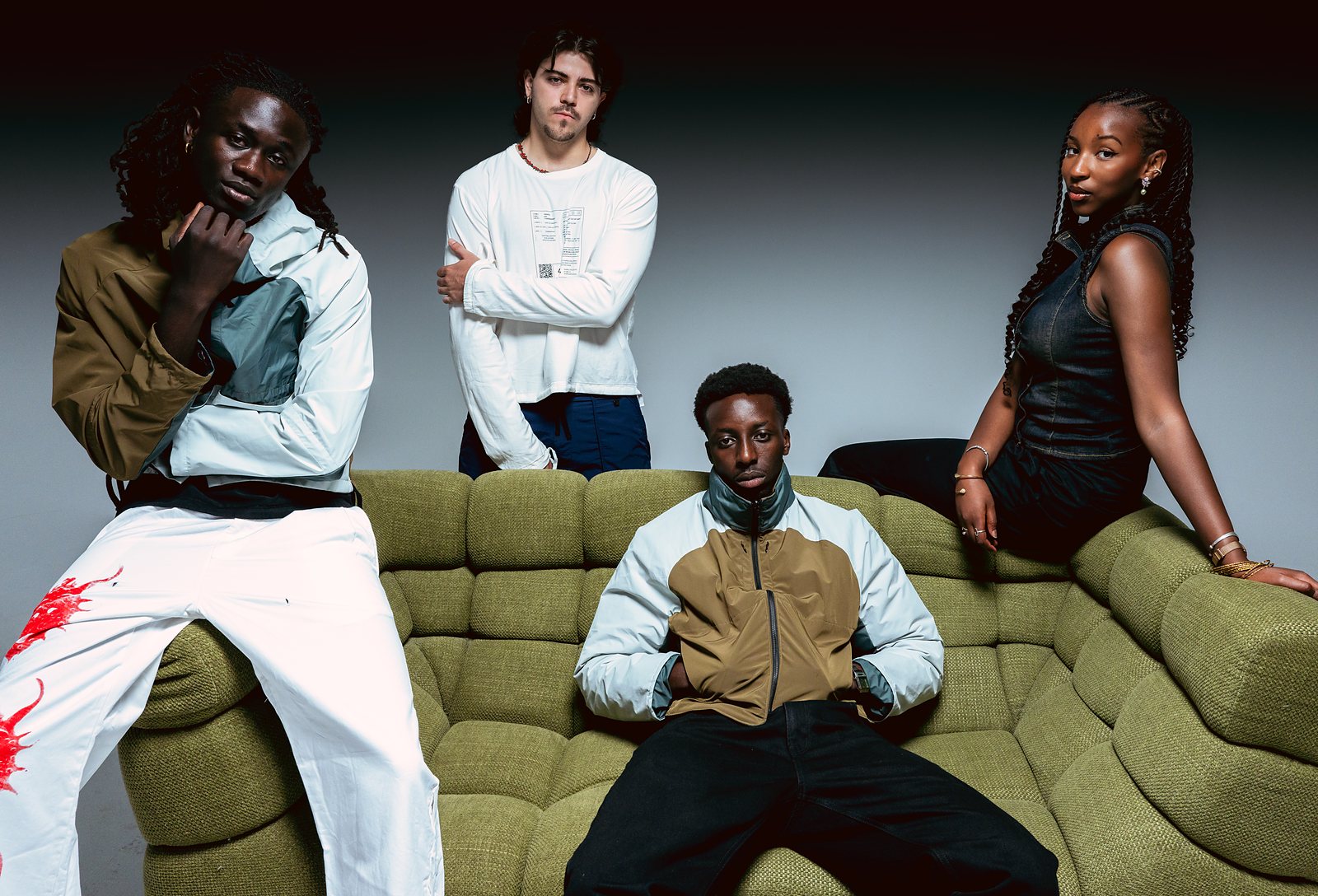 Los cuatro fundadores de TroubleMag alrededor del sofa del estudio